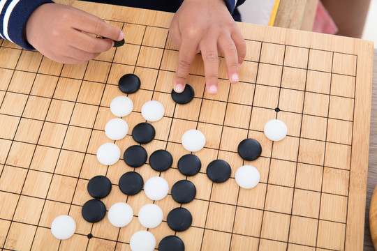 小孩子的手在摆放围棋棋子