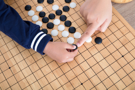 小孩子的手在摆放围棋棋子