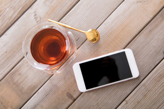 桌子上一杯红茶和一部手机