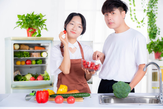 情侣从冰箱里拿蔬菜准备做饭