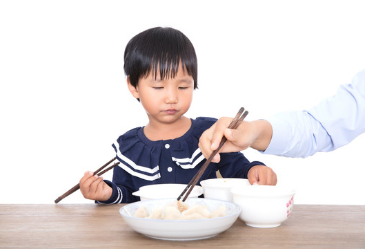 中国小姑娘在妈妈的监督下吃饺子