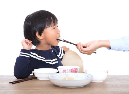 妈妈在喂孩子吃饺子