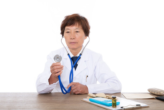 女医生坐在桌子前手拿听诊器