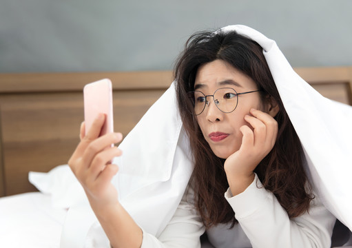 懒散的中国女孩床上玩手机