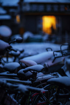 清晨的自行车积雪和饭馆门口的灯