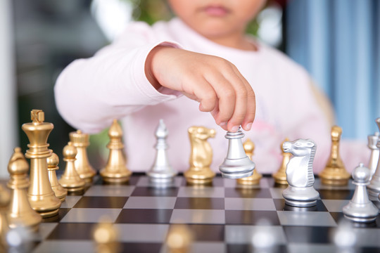 拿着国际象棋棋子在棋盘上下棋