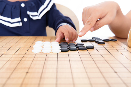 在老师的教导下孩子在学习下围棋