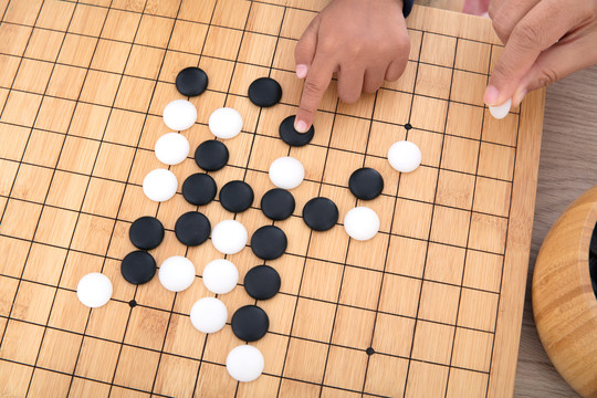 手指导着小孩的手下围棋