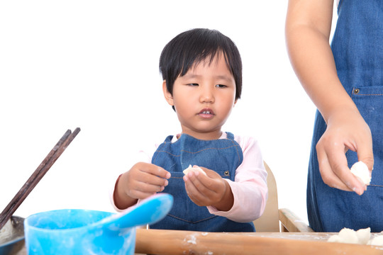 中国小女孩在学习压饺子皮