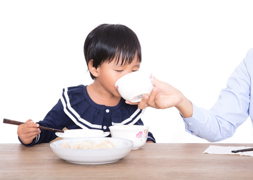 白背景前的妈妈在喂孩子吃饭