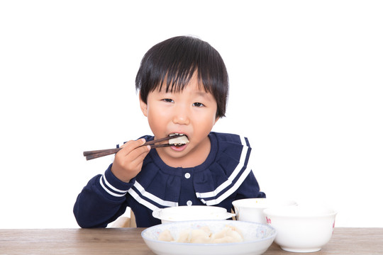 可爱的中国小女孩在吃饺子