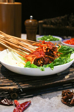 放在白盘上的虫草花牛肉串串