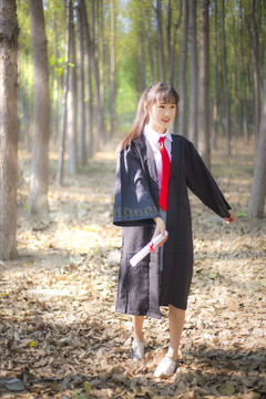 树林里穿着学士服的女孩