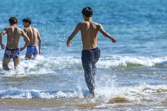 青岛海景三个扑水少年