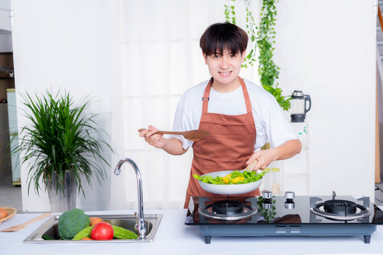 在厨房炒菜的年轻男人