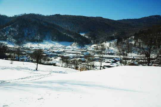 冬天积满白雪的山坡和山村