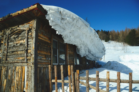 寒冬蓝天下积满厚雪的木屋