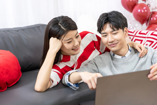 年轻情侣在家使用笔记本电脑