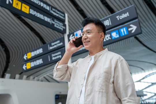 老年男人在机场打电话