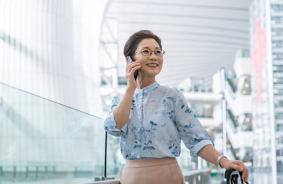 老年女人在机场打电话