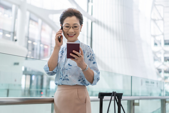 老年女人在机场打电话