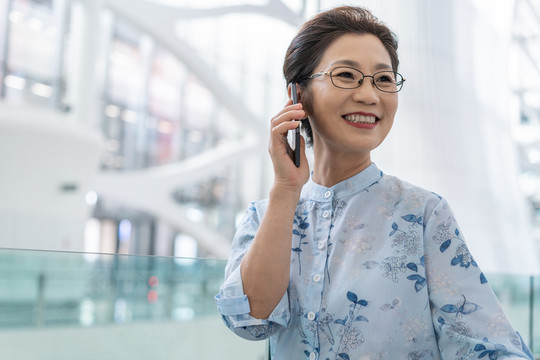 老年女人在机场打电话