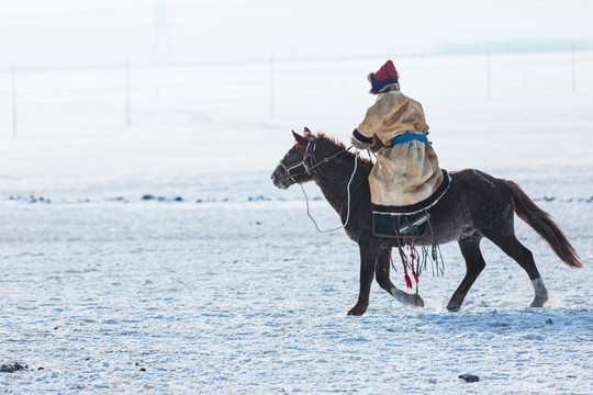 雪原蒙古族骑马奔跑