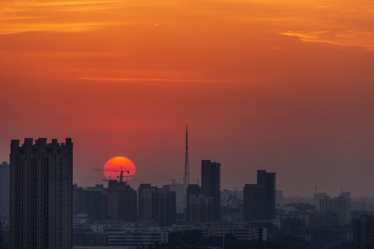 城市塔吊处升起红太阳