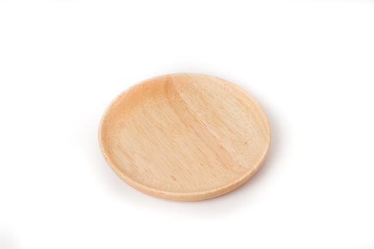 白色桌面上的圆形实木盘子