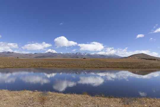 蓝天白云塔公草原雪山水面光影