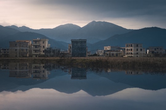 山脚下村庄在水中的倒影