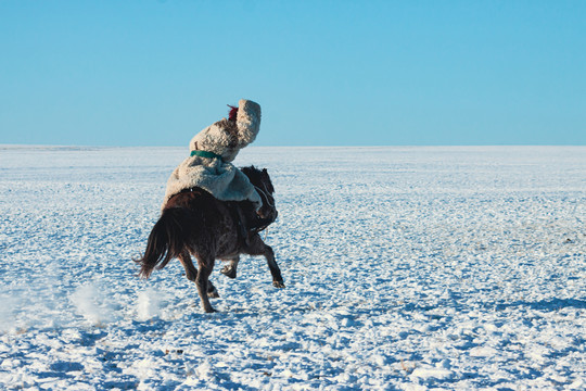 雪原蒙古族骑马奔跑