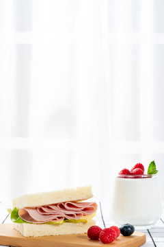 桌子上的火腿三明治早餐和酸奶