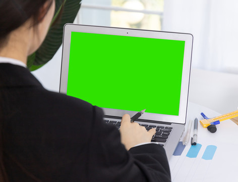 年轻商务女性在绿屏电脑前工作