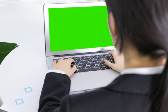 年轻商务女性在绿屏电脑前工作
