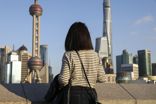 站在城市江边看风景的女人背影