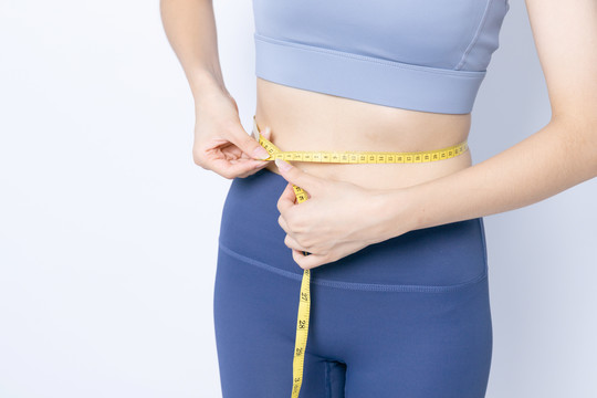 软尺测量腰围的年轻女性