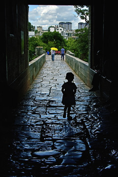 从古石板路上走过的小女孩