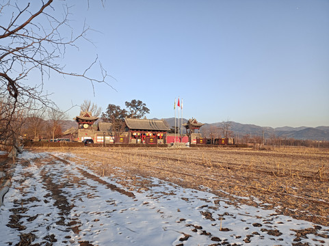 北方冬天大山下田野间的古建筑