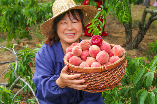 女人手上抱着一筐胭脂红桃子