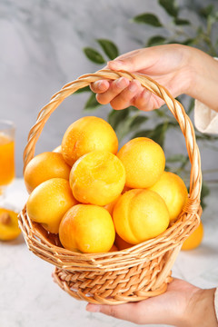 手上提着一篮黄油桃