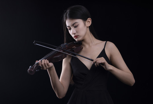 黑色背景里拉小提琴的女性