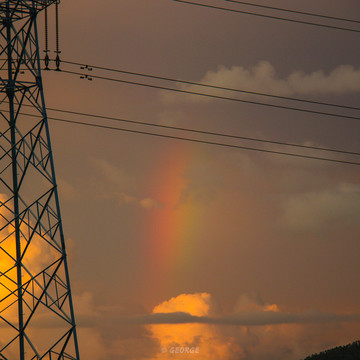 电线杆下云朵后的彩虹