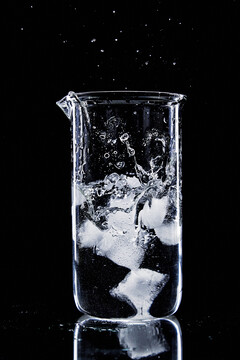 冰块丢入水杯里溅起水花