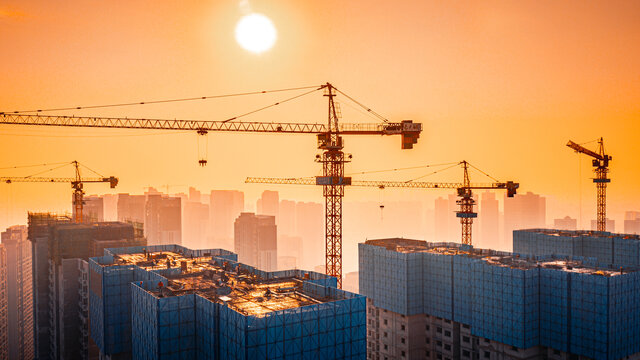 夕阳下城市建组施工吊机