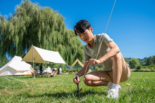 男孩在露营地搭建帐篷