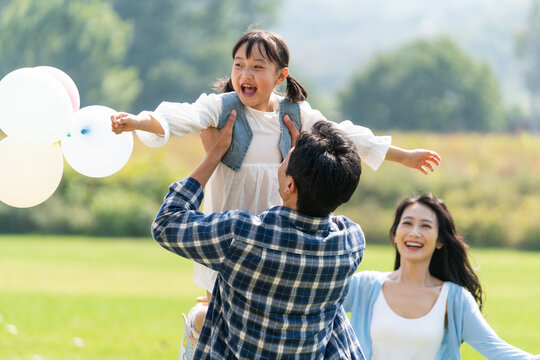 妈妈和女儿开心地跑向爸爸的怀抱