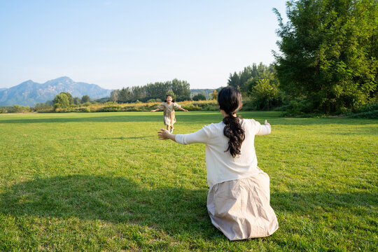 妈妈和女儿在草地上做游戏