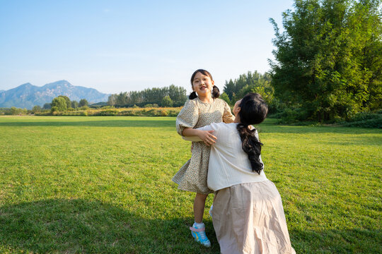 妈妈和女儿在草地上做游戏