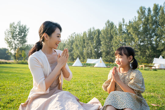 妈妈和女儿在草地上做游戏